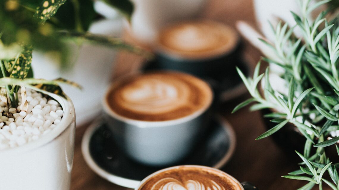 shallow focus photography of coffee late in mug on table