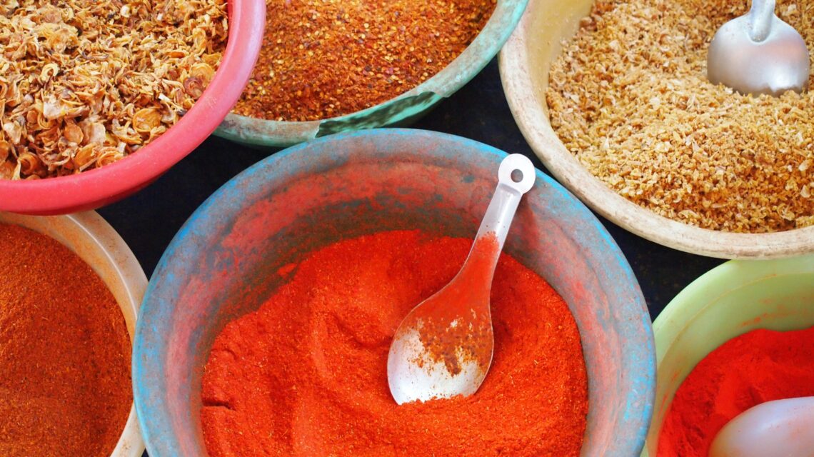 bowls of various spices and spoons on a table