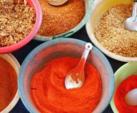 bowls of various spices and spoons on a table