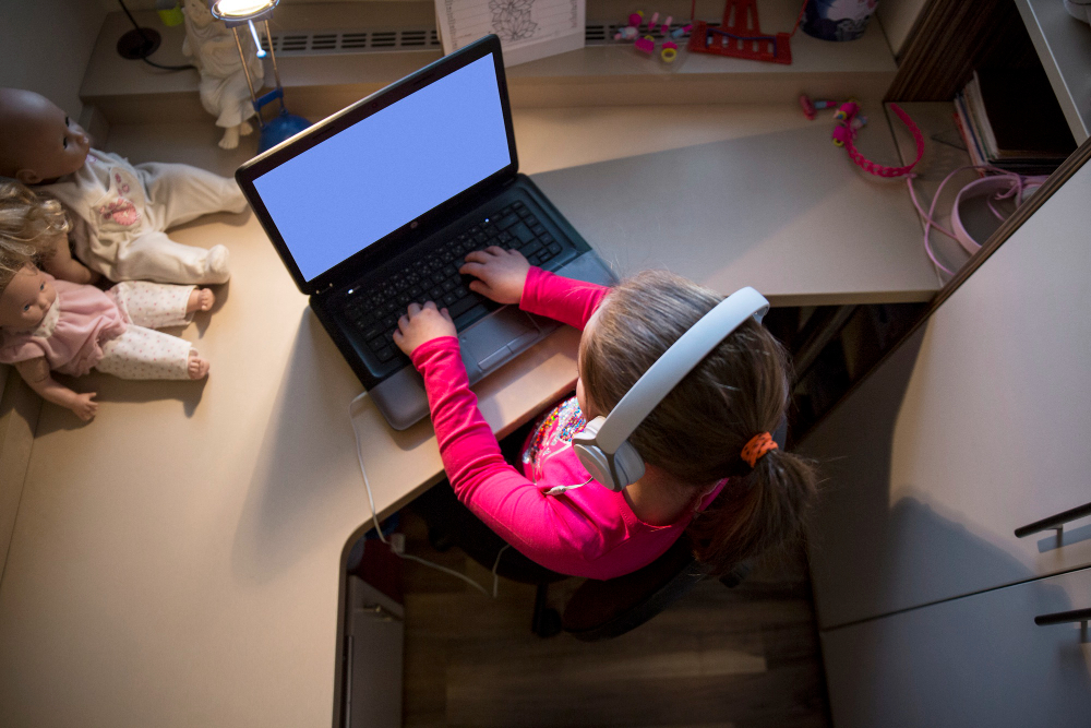 Child learning online at home with headphones and laptop, representing digital education and remote learning for kids