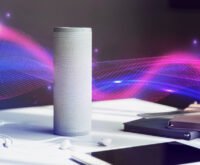 Smart voice assistant speaker on a desk with colorful sound wave graphics symbolizing voice interaction and AI technology