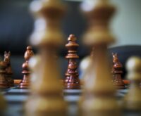Chess pieces on a board, representing a crushing business strategy for market dominance.