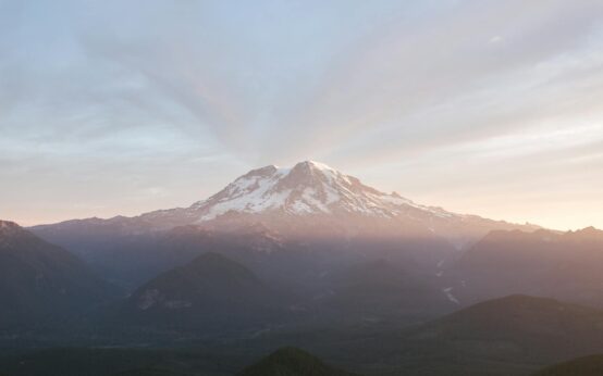 Misty sunrise illuminating a mountain landscape in a peaceful national park.
