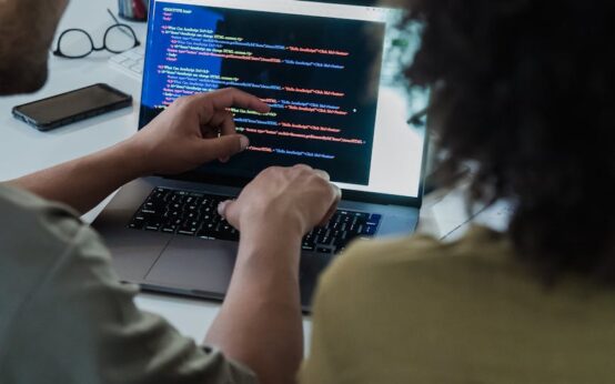 A WordPress theme developer's laptop screen showing code next to a graphic of increasing revenue.