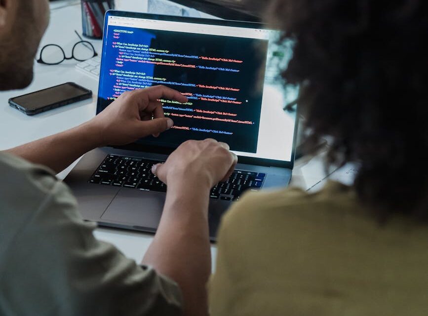 A WordPress theme developer's laptop screen showing code next to a graphic of increasing revenue.