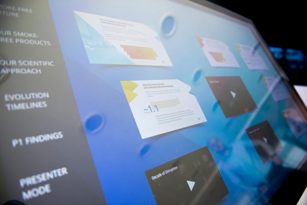 A futuristic humanoid robot touching a holographic interface displaying complex data charts and graphs.