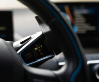 A futuristic, glowing dashboard of an autonomous vehicle showing a holographic map.