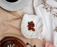 A warm bowl of oatmeal topped with sliced bananas and almonds, a perfect snack to eat for better sleep.