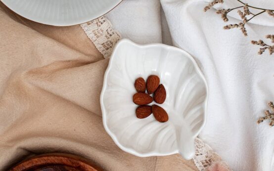 A warm bowl of oatmeal topped with sliced bananas and almonds, a perfect snack to eat for better sleep.