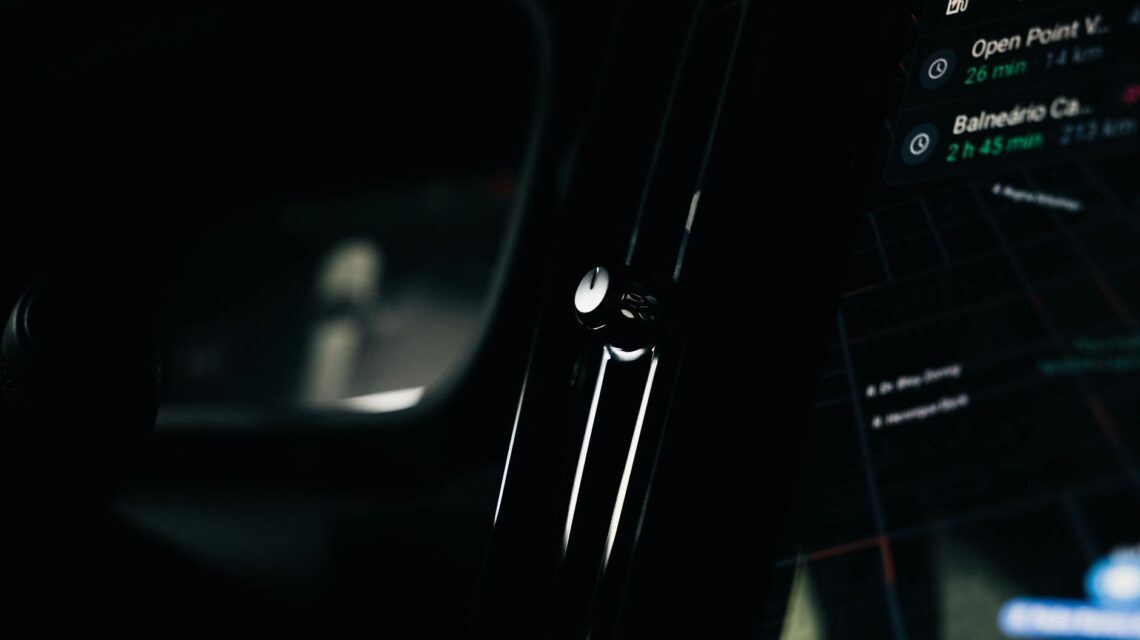 A futuristic view from inside an autonomous vehicle showing a holographic dashboard and city lights.