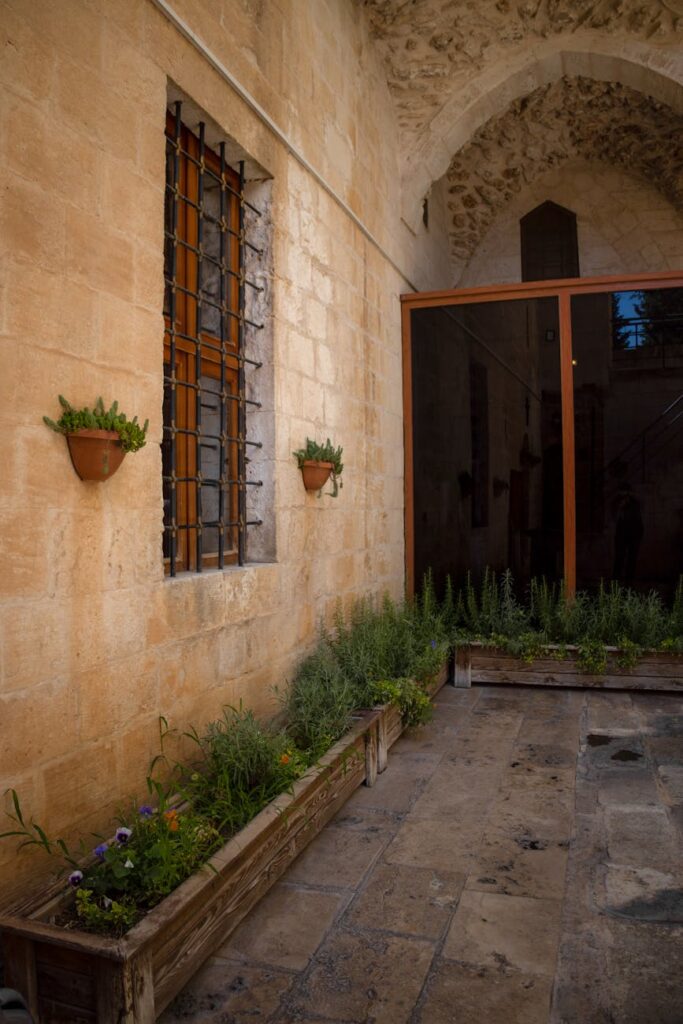 A tranquil Mediterranean courtyard with vibrant bougainvillea, terracotta planters, and whitewashed walls creating a peaceful oasis.