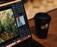 A creative professional editing a photograph on a modern laptop in a cozy cafe setting.