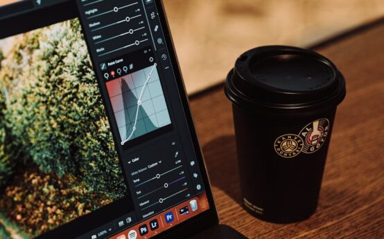 A creative professional editing a photograph on a modern laptop in a cozy cafe setting.