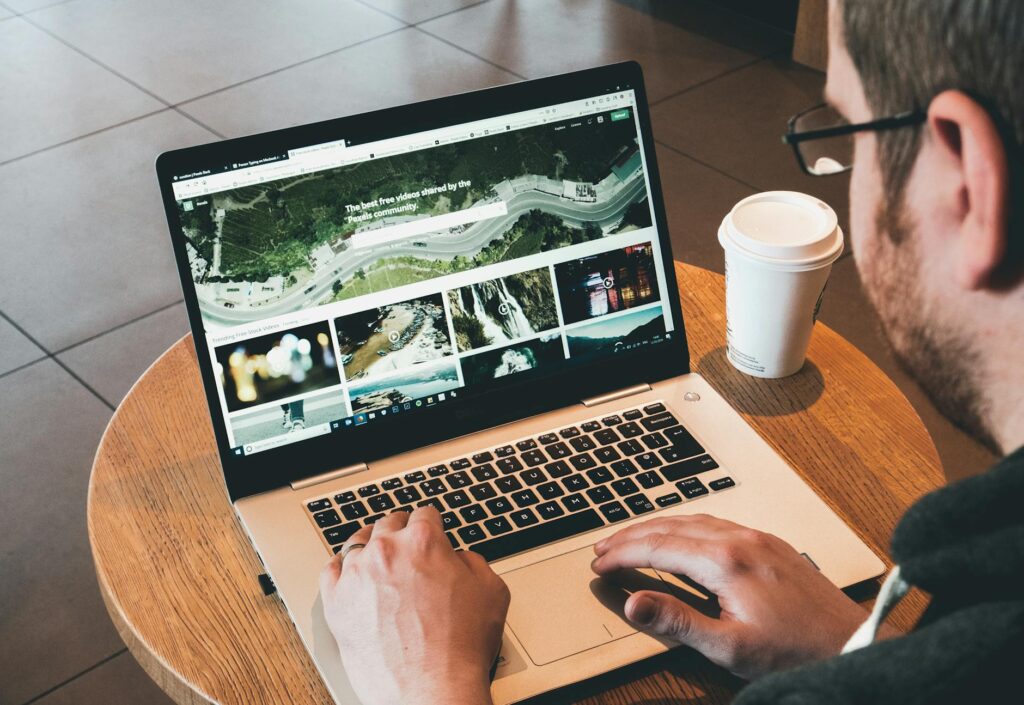 A close-up shot of a person's hands typing on a laptop, with a cup of coffee nearby.