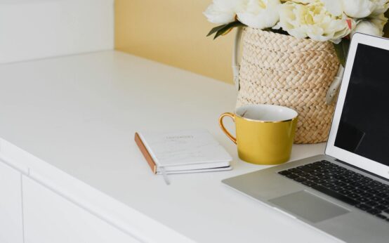 A clean and modern home office setup with a laptop, a cup of coffee, and a planner, representing the start of a new blog.