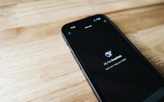 A person's hand reaching out and touching a glowing, holographic interface showing complex data networks, symbolizing the human-AI connection.