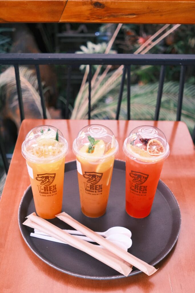 A tall, clear glass filled with iced green tea, garnished with fresh mint leaves and a slice of lime.