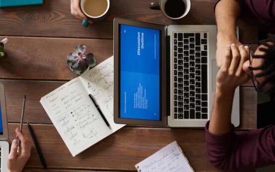 A person and a humanoid robot collaborating over a tablet in a bright, modern office setting.