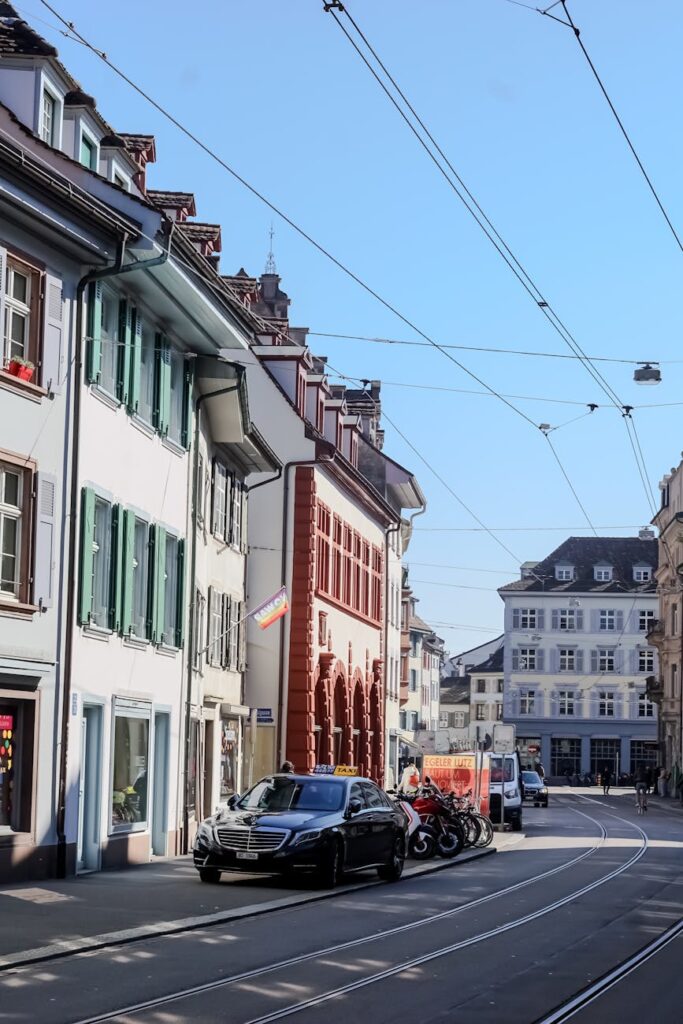 A modern white and blue tram gliding down a picturesque, tree-lined street in Zurich, Switzerland.