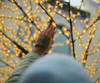 A person's finger touching a glowing blue digital brain, symbolizing the human-AI connection.
