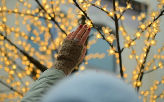 A person's finger touching a glowing blue digital brain, symbolizing the human-AI connection.