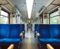 The clean, quiet, and empty interior of a Japanese Shinkansen bullet train, with rows of neat seats.