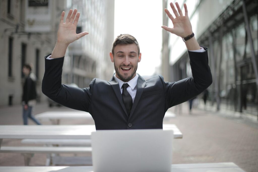 A happy woman looking at her laptop screen which shows a rising income graph from her blog.