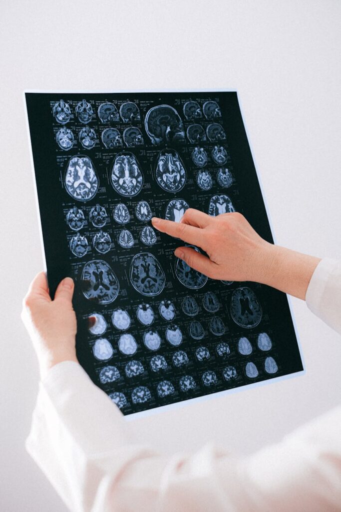 A medical professional analyzing a digital brain scan that has glowing highlights from an AI diagnostic tool.