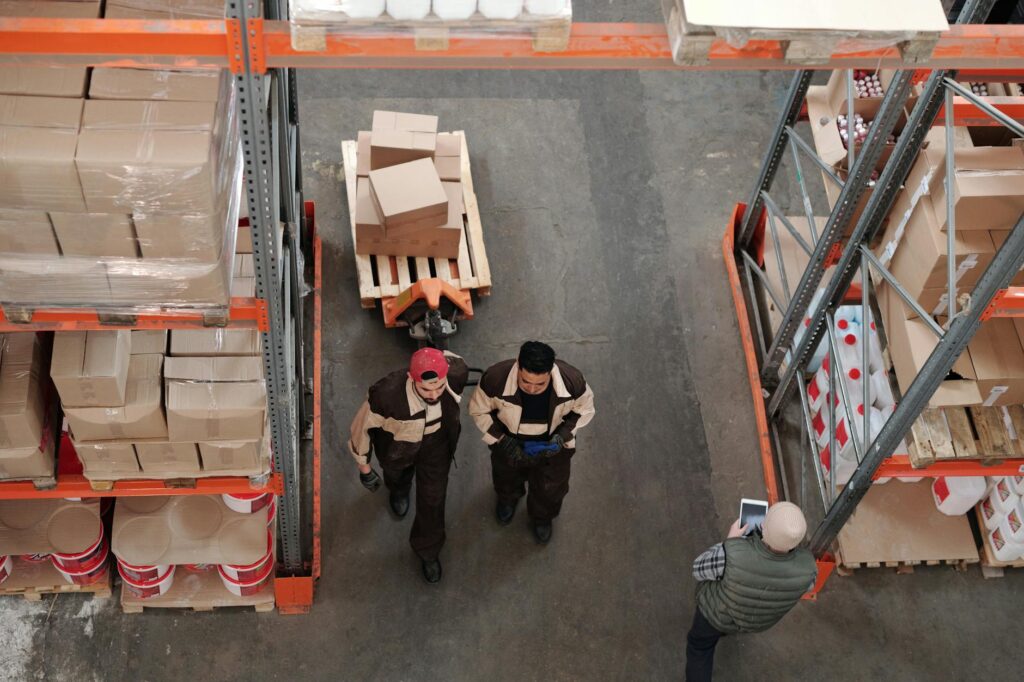 An automated robot arm efficiently organizing packages in a brightly lit e-commerce warehouse.