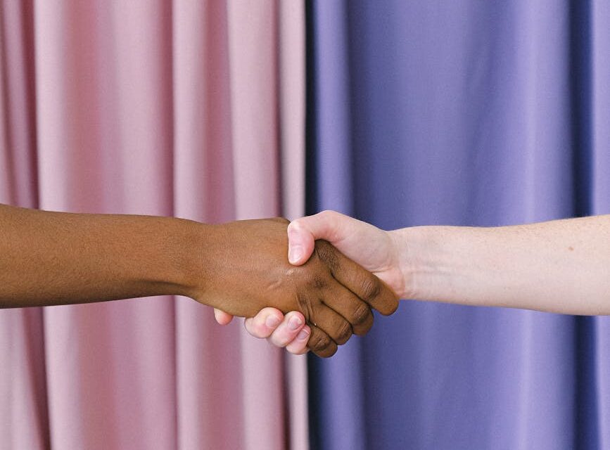 A collaborative handshake between a human hand and a robotic hand, symbolizing human-AI partnership.