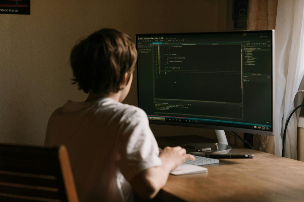 A developer coding a smart contract on a computer with blockchain diagrams in the background.