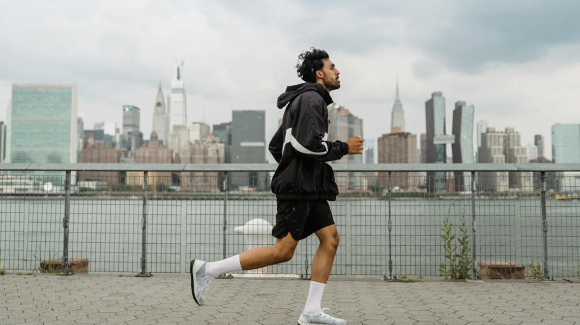 A person blending a fruit smoothie in a kitchen before a workout.