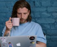 A photographer editing a vibrant landscape photo on their laptop in a cozy home office setting.