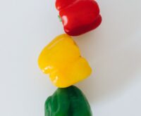 A person's hands holding a cereal box, their finger pointing to the high sugar content on the nutrition facts label.