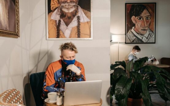A person sitting at a comfortable home office desk, focused on their laptop while planning an online side hustle.