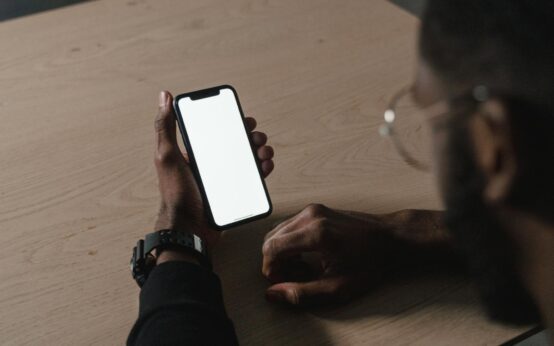 A creator smiling while looking at their smartphone which displays a graph of their earnings.