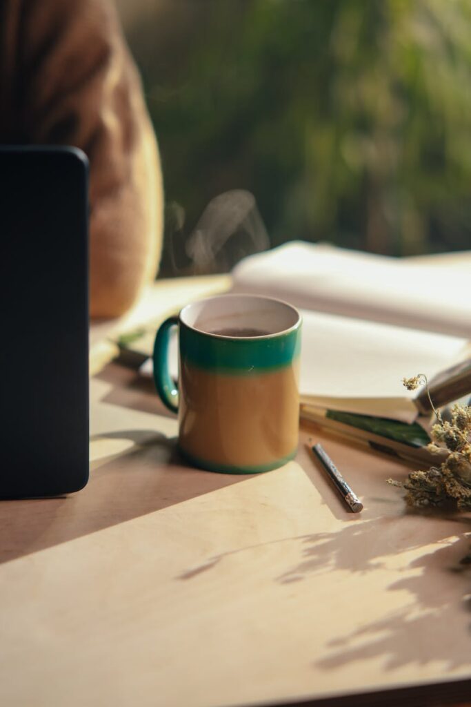 A top-down view of a desk with a laptop showing an Instagram profile, a notebook, and a stack of cash.