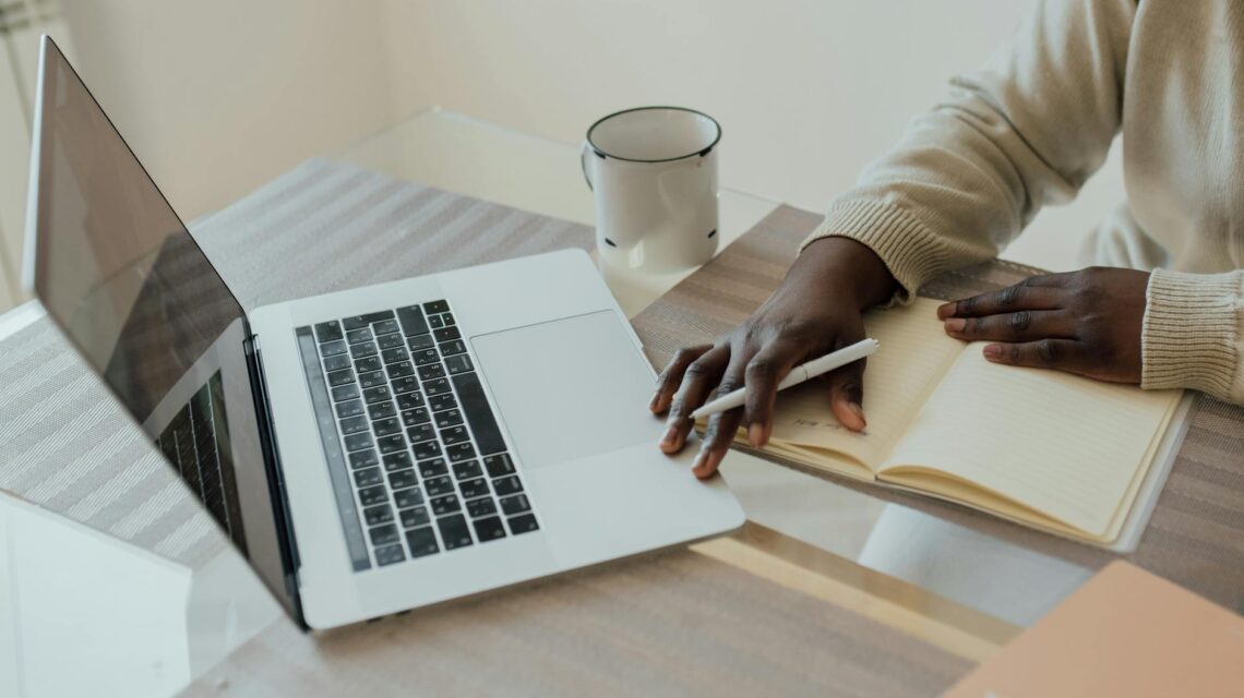 A freelancer typing on their laptop in a comfortable home office setting, focused on earning money online.