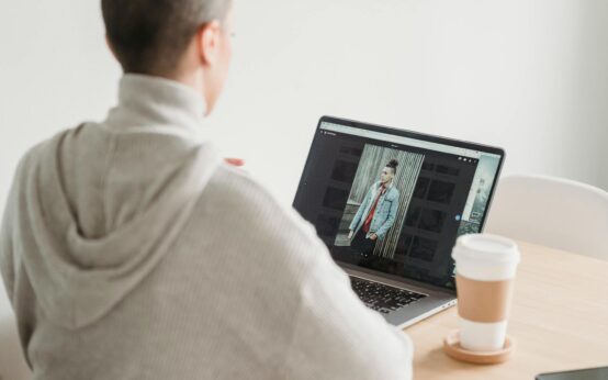 A person relaxing on a comfortable couch, earning money online with a laptop and a cup of coffee nearby.