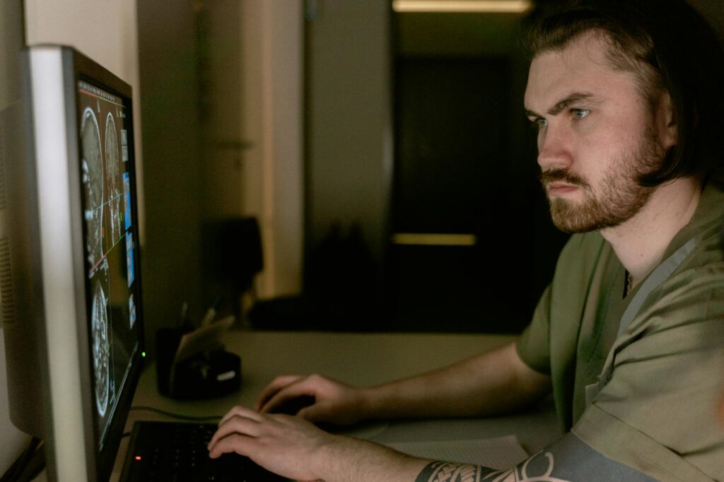 A healthcare professional in scrubs analyzing a detailed MRI brain scan on a futuristic transparent screen displaying AI-driven diagnostics.
