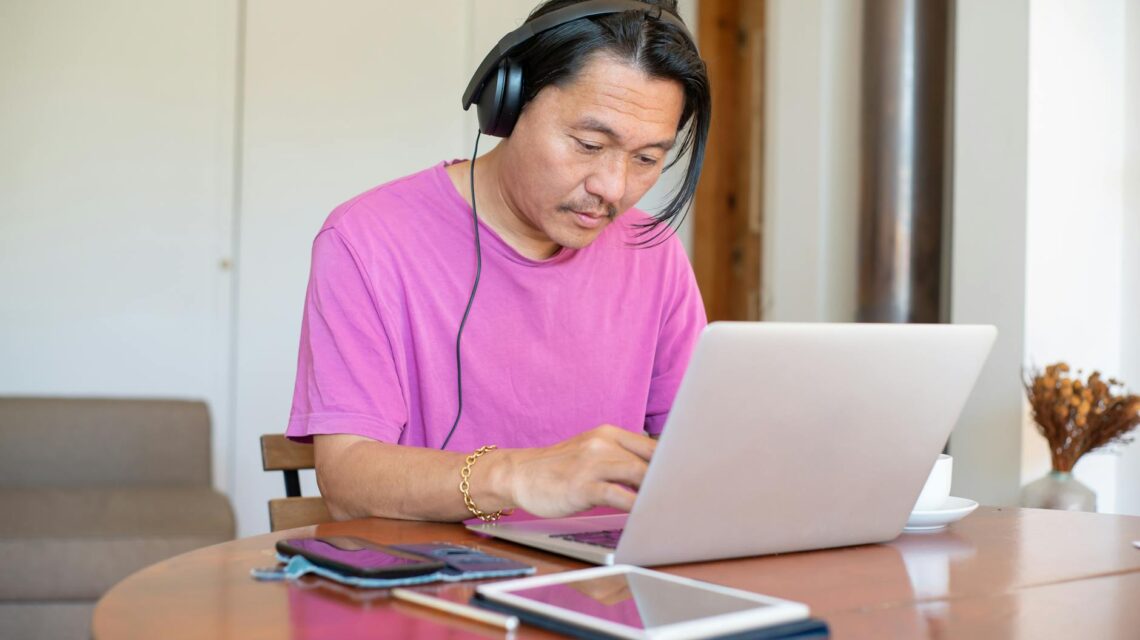 A person smiling while working on their online side hustle from a comfortable home office.