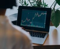 A small business owner analyzing charts and graphs on a laptop, representing AI-driven business intelligence.