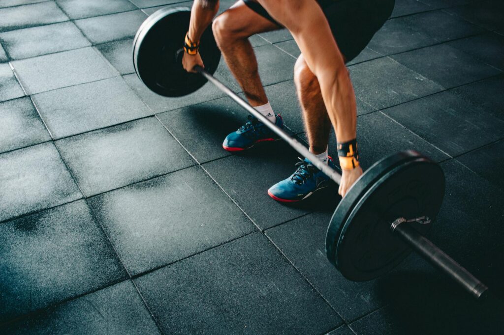 A fit person in athletic wear performing a burpee in their living room, demonstrating a HIIT workout.
