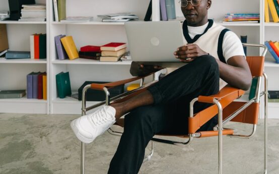 A young student smiles while interacting with a holographic display on a futuristic tablet for a personalized learning experience.