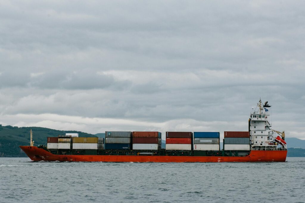 Close-up of an IoT sensor with a blinking light attached to a metal shipping container, symbolizing real-time tracking.