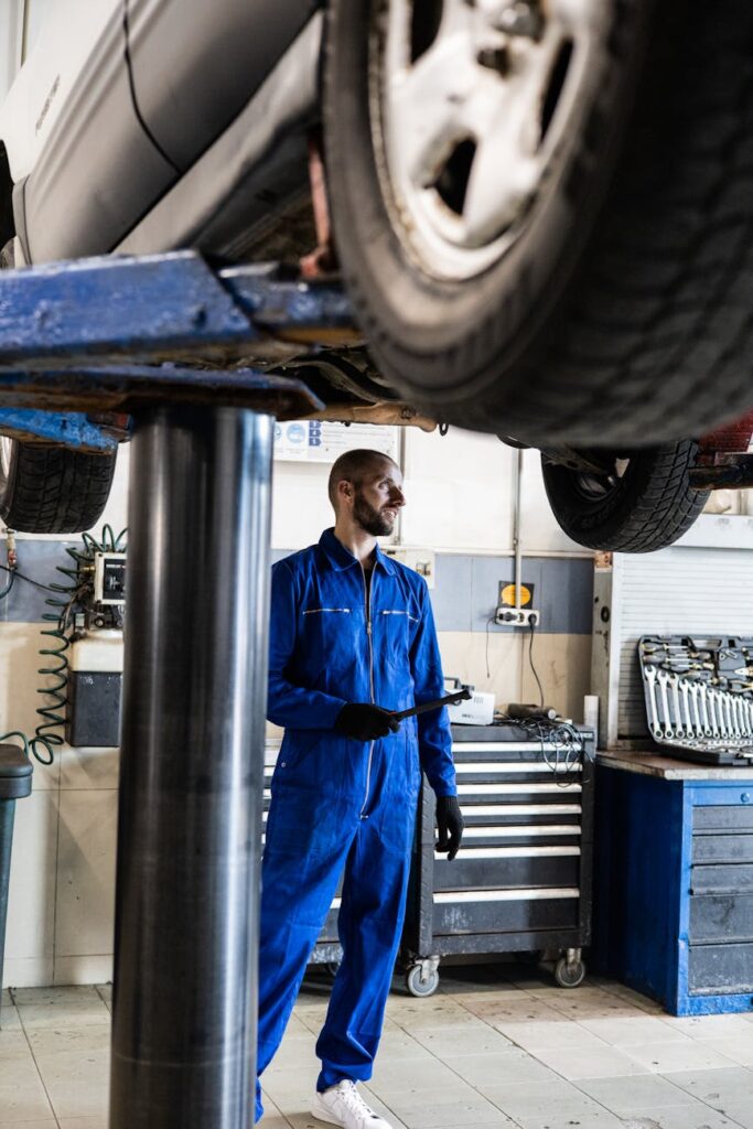 A transportation technician using a laptop to diagnose the complex wiring of an electric, AI-enabled truck.