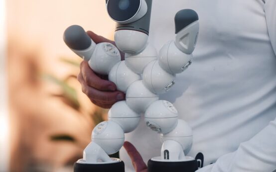 A metallic robot hand and a human hand clasped in a handshake, symbolizing the collaboration between AI and people.