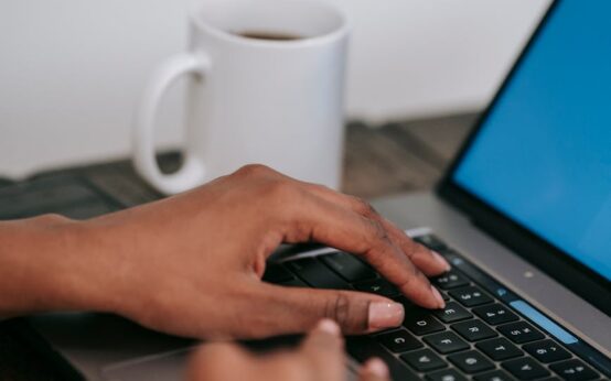 A woman smiling while working as a virtual assistant from her bright, modern home office.