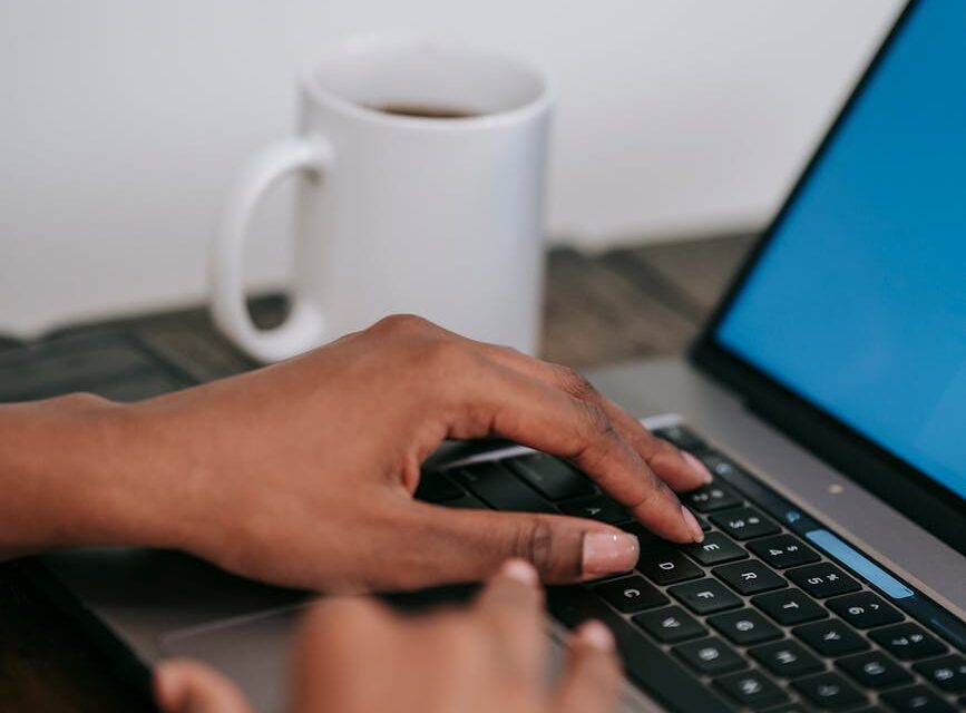 A woman smiling while working as a virtual assistant from her bright, modern home office.