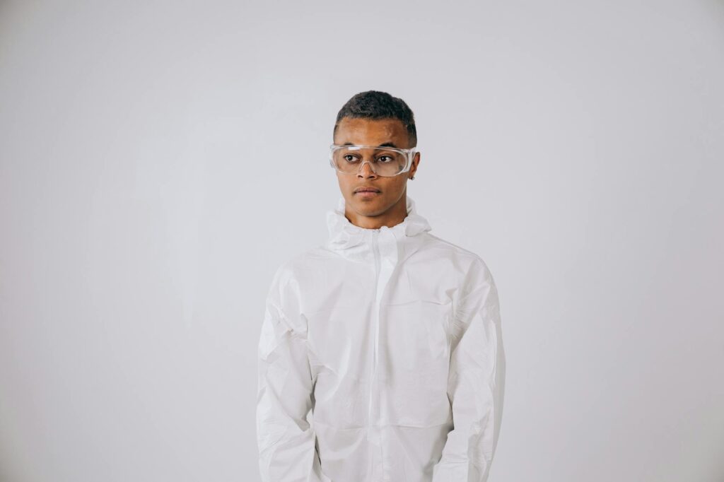 A researcher in full protective gear working in a sterile nanotechnology laboratory.